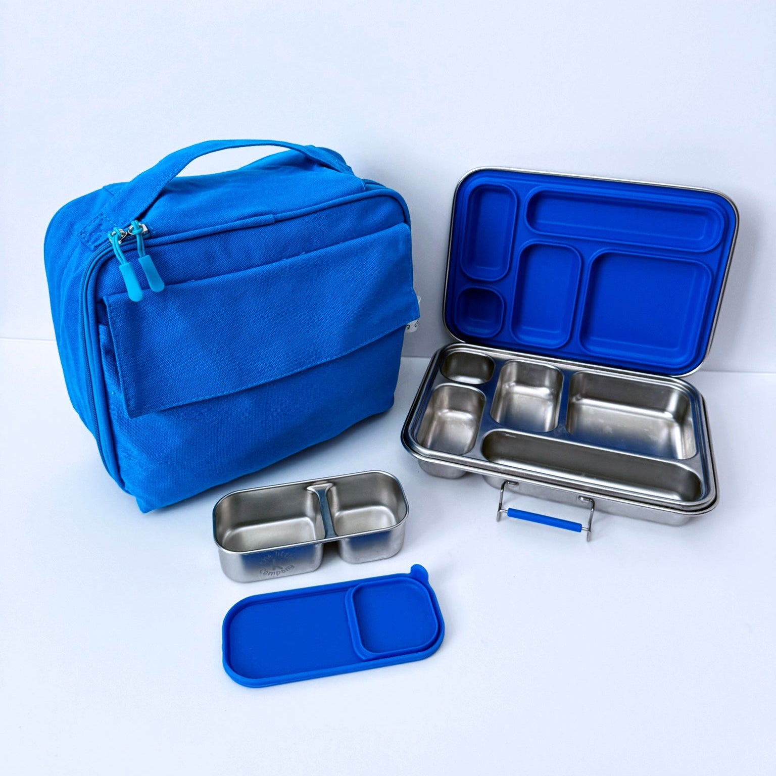 A blue lunch bag and stainless steel bento box set with blue lids, arranged on a clean white background.