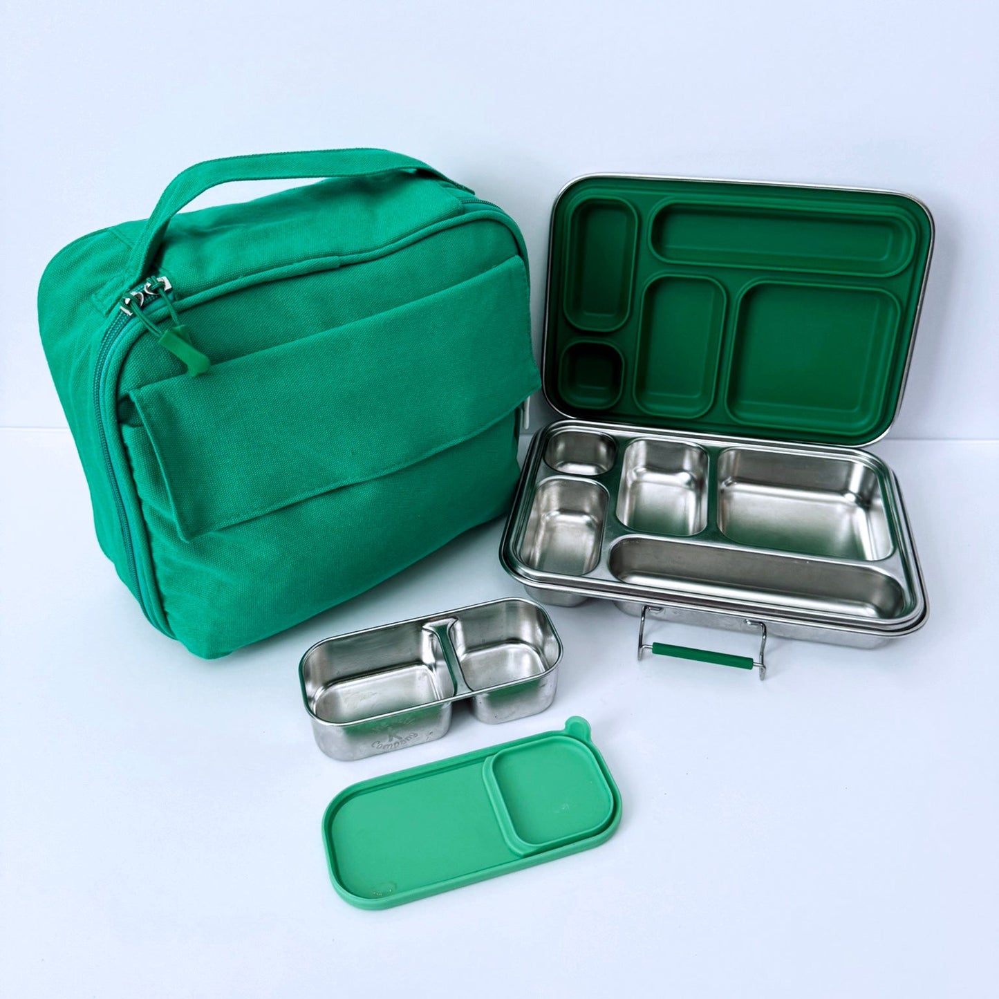 Green lunch bag and stainless steel bento box set with multiple compartments, shown on a clean white background.
