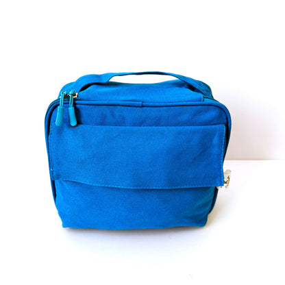 A GOTS certified organic cotton bright blue fabric zippered lunch bag with a top handle, shown against a plain white background.