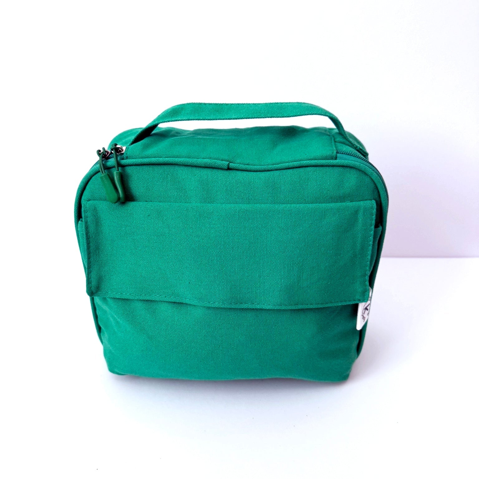 A green canvas lunch bag case with a top handle, shown against a plain white background.